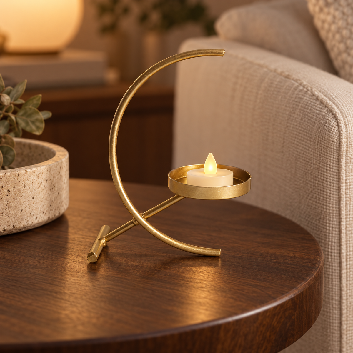 Crescent gold-tone tealight holder — lifestyle view; candle and styling props not included
