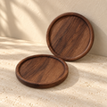 Round walnut coaster pair — hero view